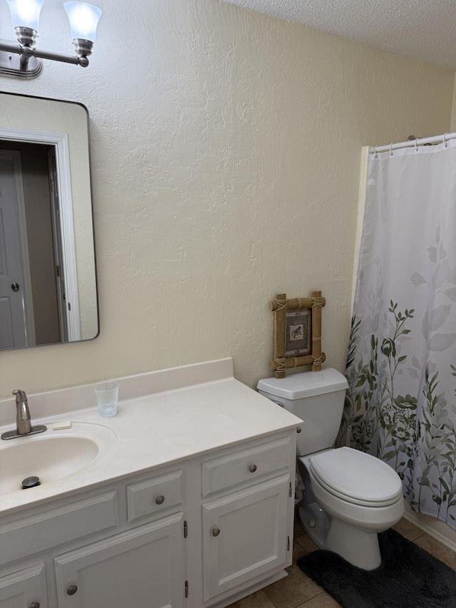 bathroom featuring tile patterned flooring, a shower with shower curtain, vanity, a textured ceiling, and toilet