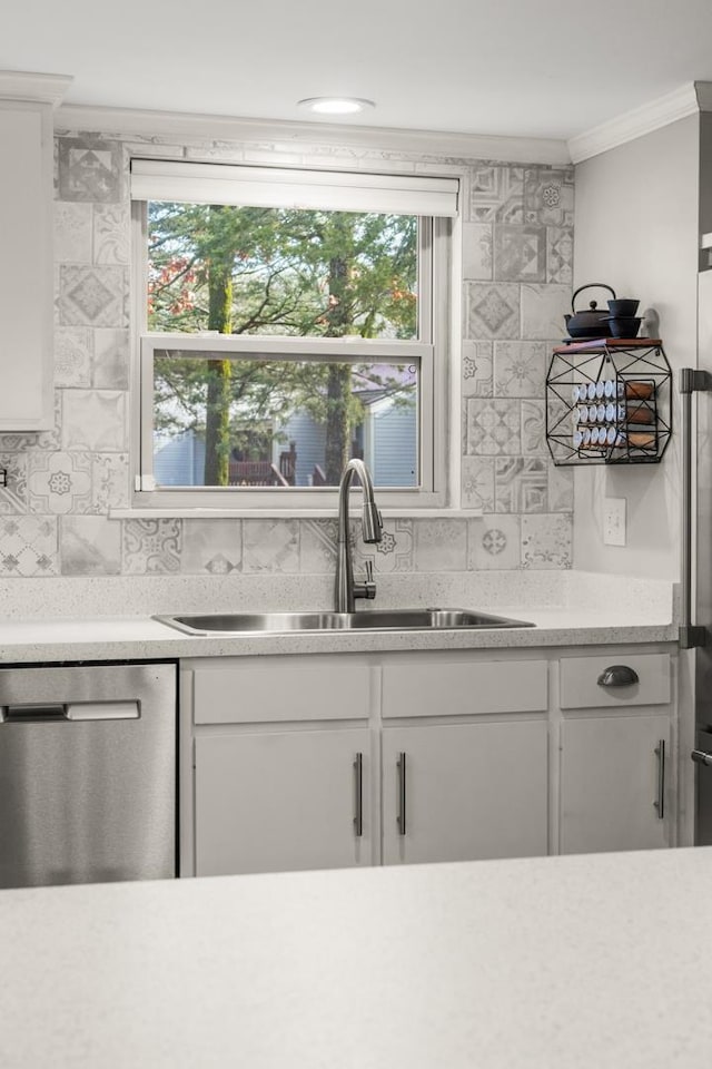 kitchen with sink, white cabinetry, crown molding, dishwasher, and decorative backsplash