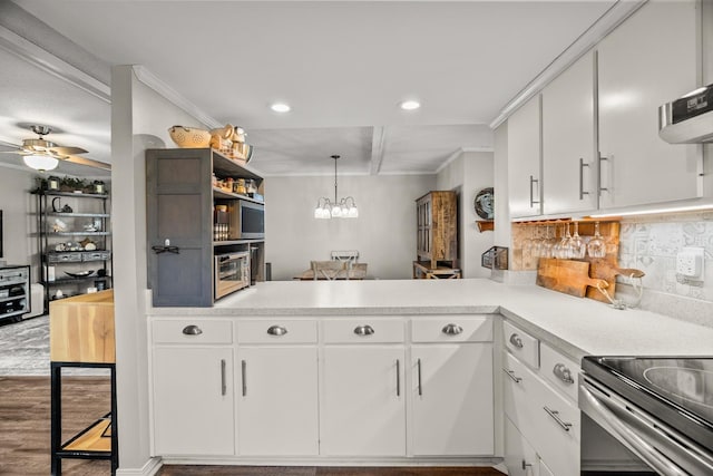 kitchen featuring white cabinetry, tasteful backsplash, kitchen peninsula, and hanging light fixtures