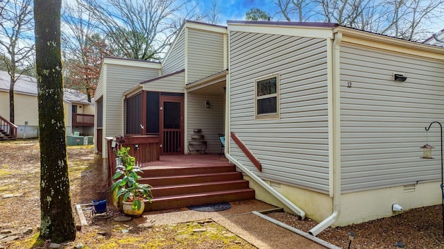 view of home's exterior with a sunroom and a deck