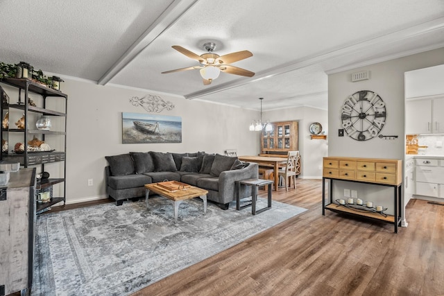 living room with crown molding, ceiling fan with notable chandelier, a textured ceiling, and light hardwood / wood-style floors