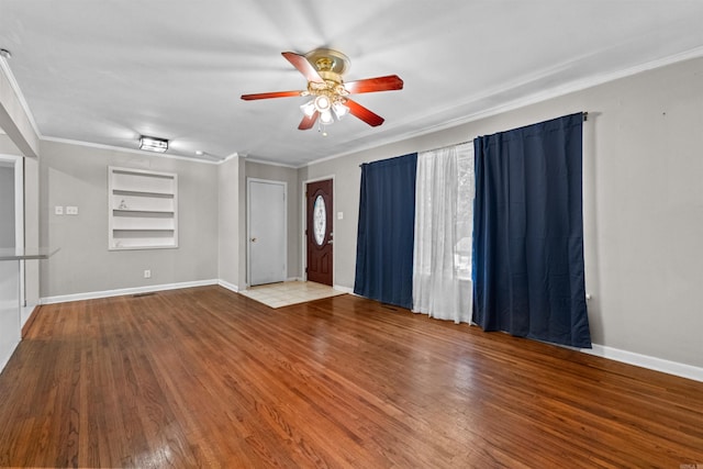 interior space featuring hardwood / wood-style floors, built in shelves, ornamental molding, and ceiling fan