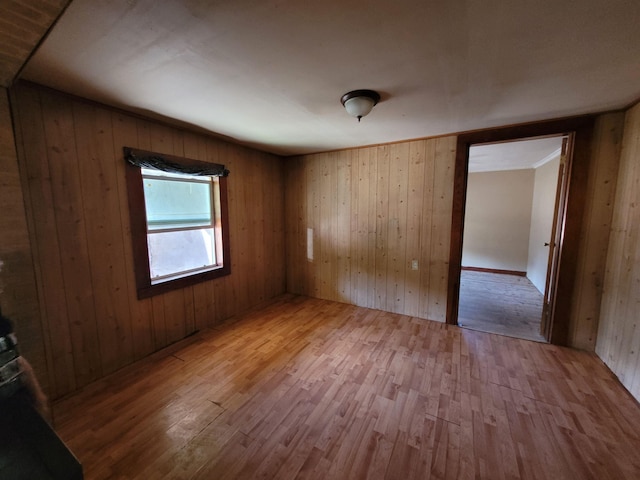 empty room featuring hardwood / wood-style flooring and wooden walls