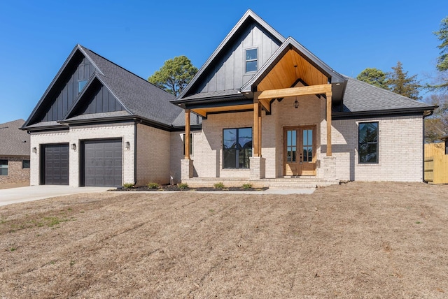 view of front of property with french doors, a porch, a garage, and a front yard