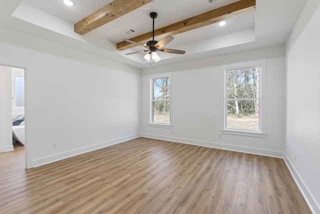 empty room with beam ceiling, light hardwood / wood-style flooring, and ceiling fan