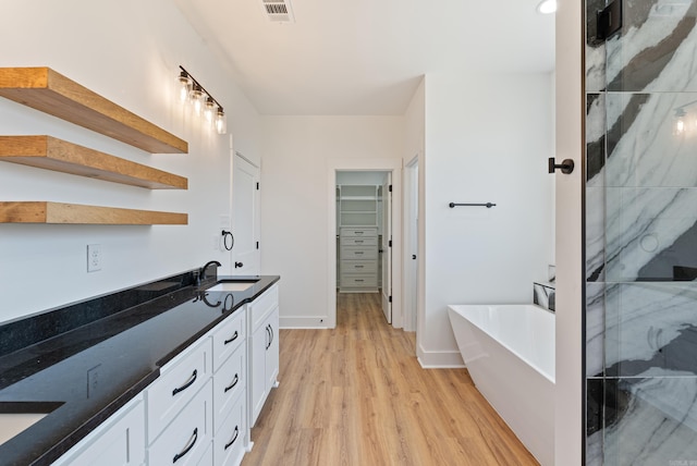 bathroom with vanity, plus walk in shower, and wood-type flooring