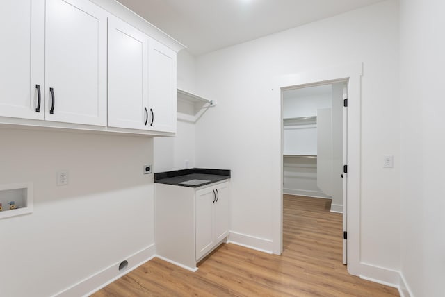 laundry room featuring hookup for a washing machine, cabinets, hookup for an electric dryer, and light wood-type flooring