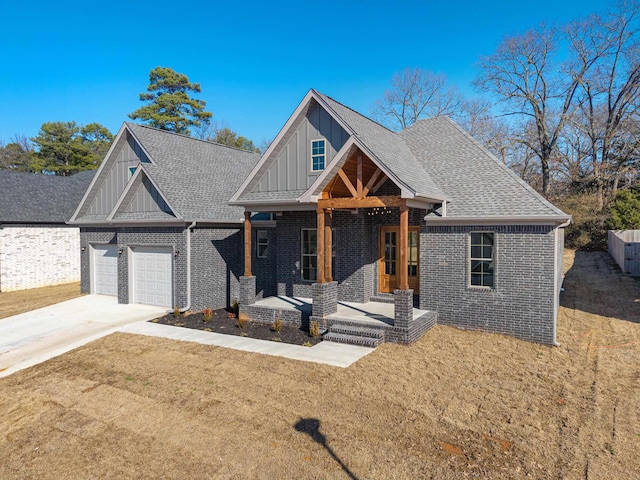 view of front of property featuring a porch, a garage, and a front yard