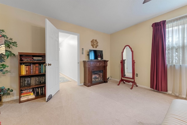 living area with light carpet and ceiling fan