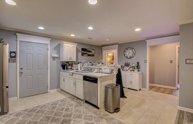 kitchen with light tile patterned flooring, appliances with stainless steel finishes, white cabinetry, sink, and kitchen peninsula