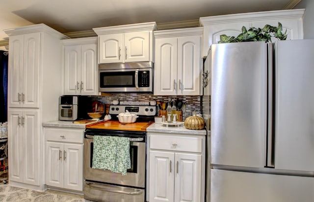 kitchen featuring tasteful backsplash, appliances with stainless steel finishes, and white cabinets