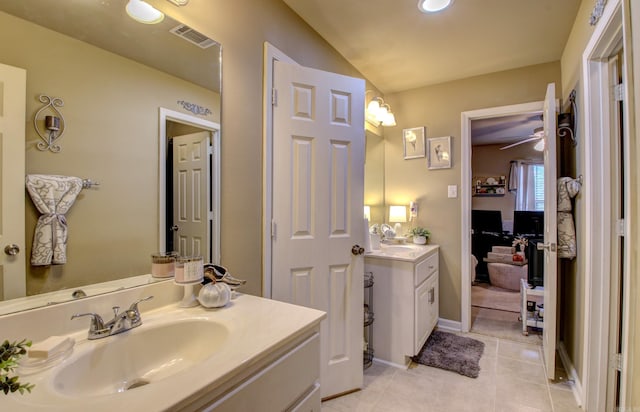 bathroom featuring tile patterned flooring, vanity, and vaulted ceiling