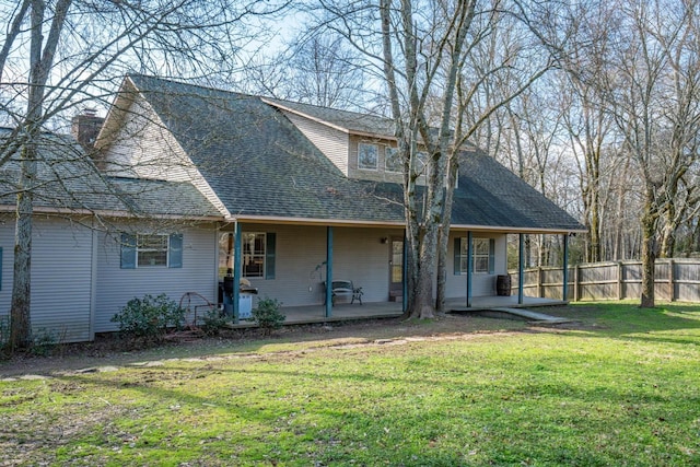 rear view of house featuring a yard