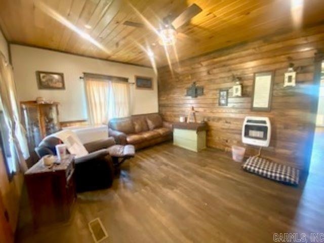 205 S Main, Okolona, AR 71962 - living room featuring heating unit, wooden walls, hardwood / wood-style flooring, ceiling fan, and wooden ceiling