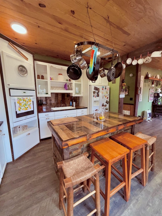 205 S Main, Okolona, AR 71962 - kitchen featuring dark hardwood / wood-style flooring, wood ceiling, white appliances, and white cabinets