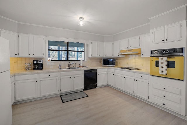 kitchen featuring sink, ornamental molding, black appliances, white cabinets, and light wood-type flooring