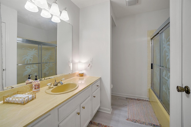 full bathroom featuring toilet, vanity, shower / bath combination with glass door, and a chandelier