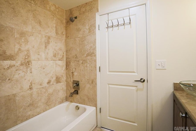 bathroom featuring vanity and tiled shower / bath