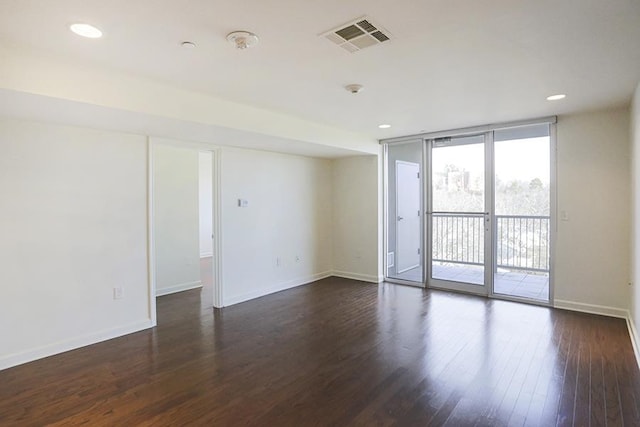 unfurnished room featuring dark hardwood / wood-style flooring and expansive windows