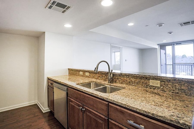 kitchen featuring dark wood-type flooring, dark brown cabinetry, sink, stainless steel dishwasher, and light stone countertops