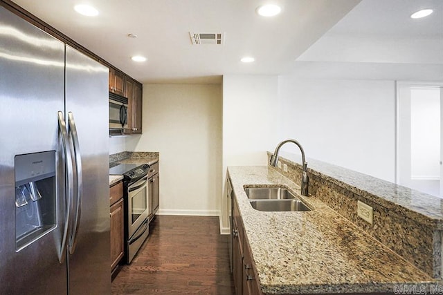 kitchen with light stone counters, sink, dark hardwood / wood-style flooring, and appliances with stainless steel finishes