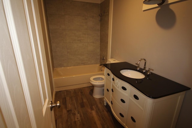 full bathroom featuring tiled shower / bath, vanity, toilet, and hardwood / wood-style floors