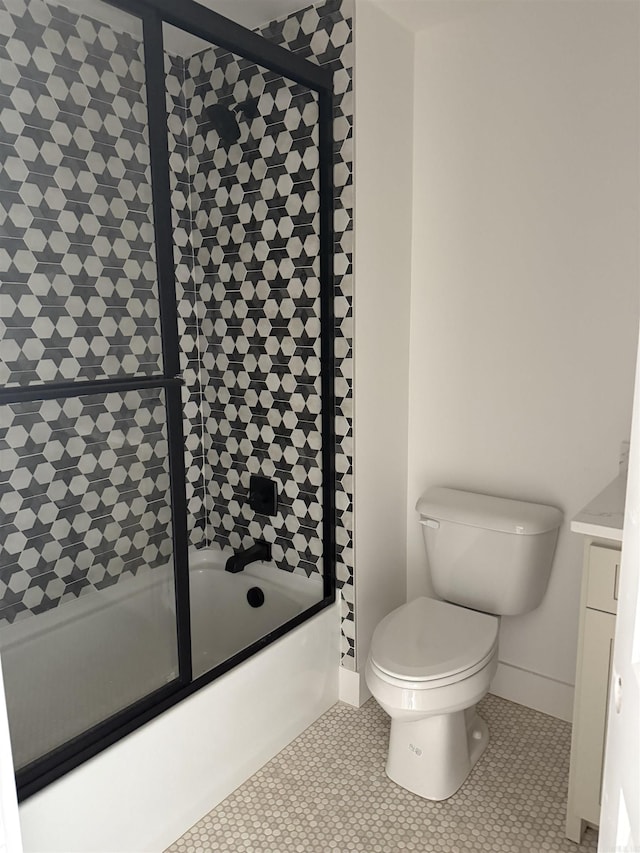 bathroom with tile patterned flooring, bath / shower combo with glass door, and toilet