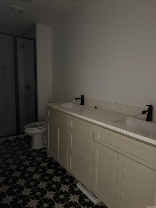 bathroom featuring vanity, a shower with shower door, and toilet