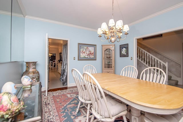 dining area with an inviting chandelier, ornamental molding, and wood-type flooring