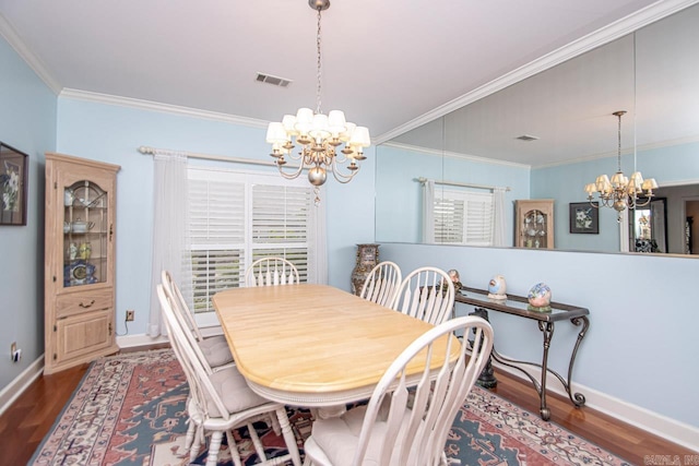 dining space featuring hardwood / wood-style flooring, ornamental molding, and a chandelier