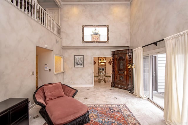 living area featuring crown molding and a towering ceiling