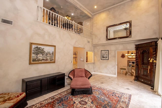 living area with crown molding and a towering ceiling