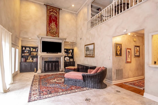 living room with crown molding, a fireplace, and a high ceiling