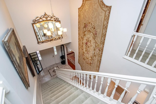 staircase with a towering ceiling and a notable chandelier