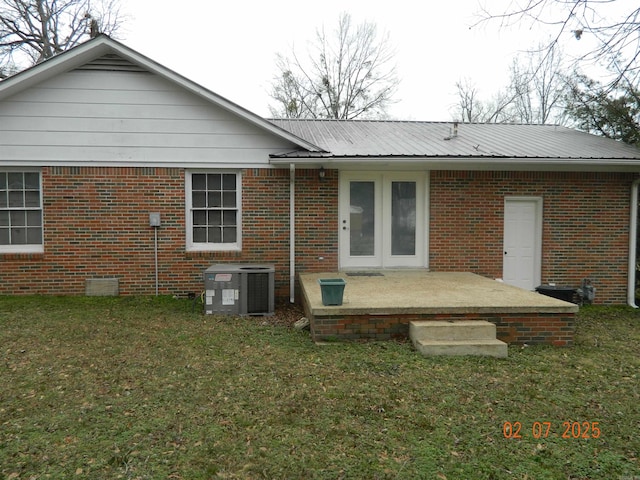 back of house with cooling unit, a lawn, and a patio area