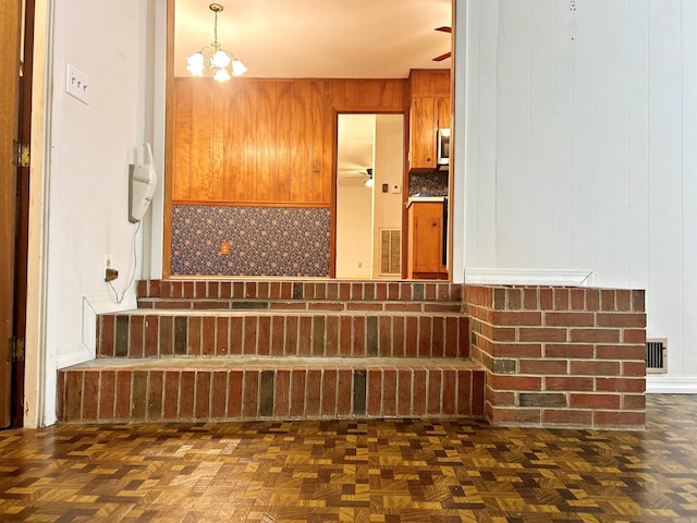 bathroom with parquet floors, backsplash, and a notable chandelier