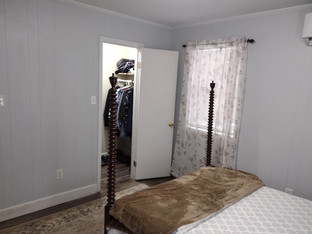 bedroom featuring crown molding, a spacious closet, hardwood / wood-style floors, and a closet