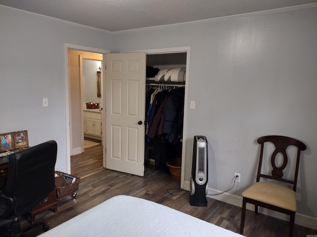 bedroom featuring ornamental molding, dark hardwood / wood-style floors, a closet, and a textured ceiling