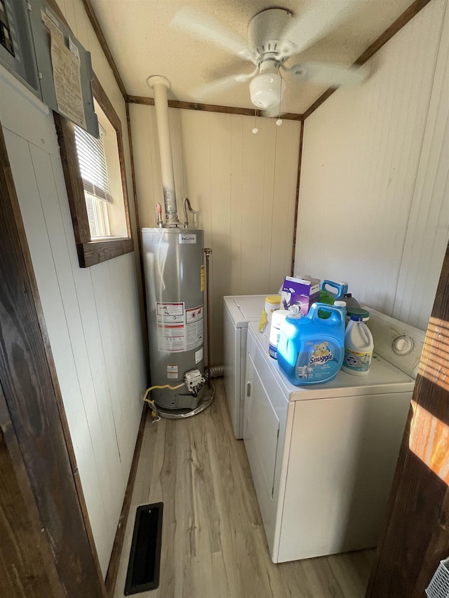 washroom featuring gas water heater, washer and dryer, ceiling fan, crown molding, and light wood-type flooring