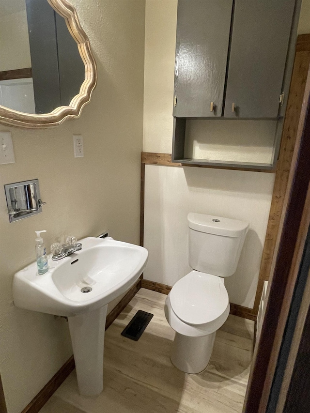 bathroom featuring wood-type flooring and toilet