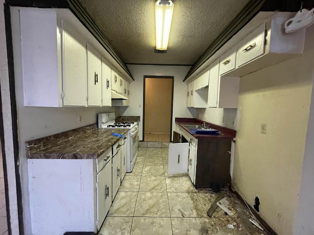 kitchen featuring light tile patterned floors, sink, white gas range oven, a textured ceiling, and white cabinets