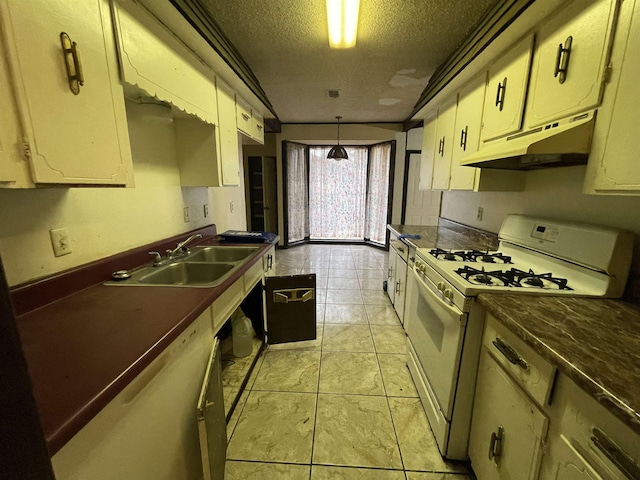 kitchen featuring light tile patterned flooring, sink, a textured ceiling, white gas range oven, and cream cabinetry