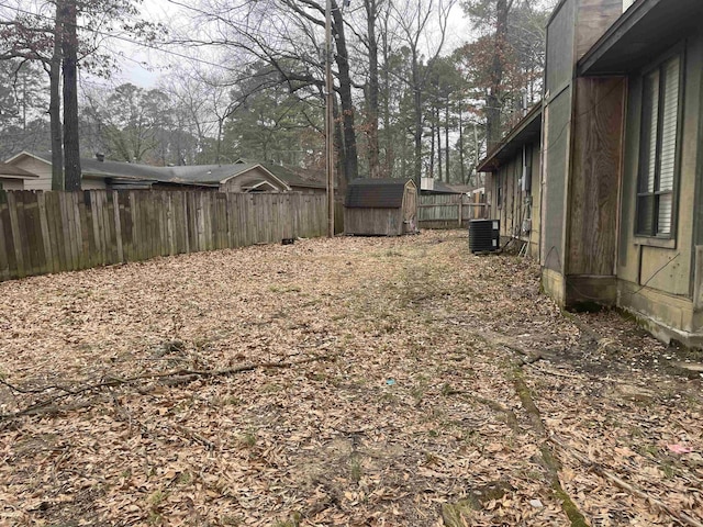 view of yard with central air condition unit and a storage unit