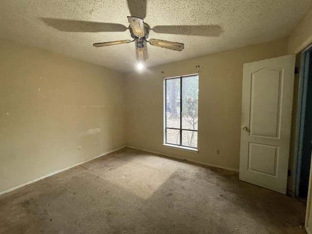 spare room with ceiling fan, light colored carpet, and a textured ceiling