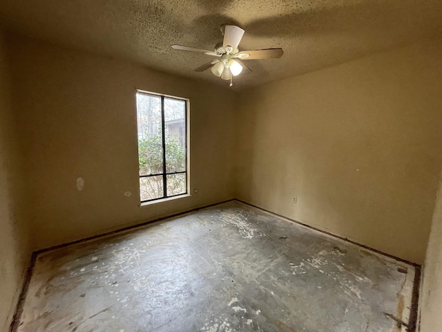 spare room featuring ceiling fan, concrete flooring, and a textured ceiling