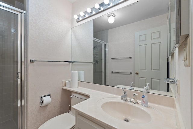 bathroom featuring vanity, a shower with shower door, and toilet