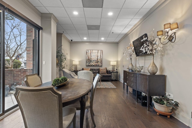 dining room with hardwood / wood-style flooring, a paneled ceiling, and ornamental molding