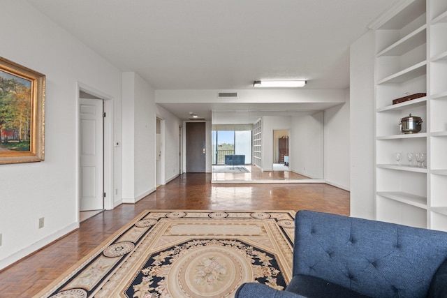 living room featuring dark parquet flooring and built in features