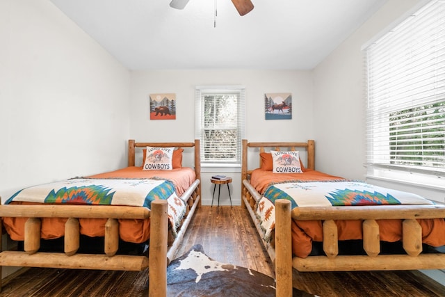 bedroom featuring multiple windows, hardwood / wood-style floors, and ceiling fan