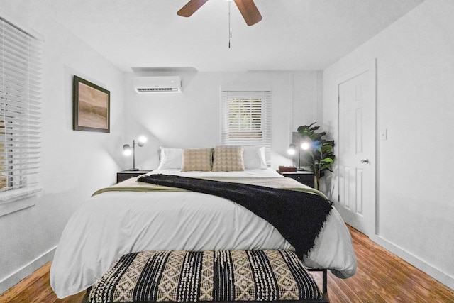 bedroom with ceiling fan, a wall mounted air conditioner, and hardwood / wood-style floors